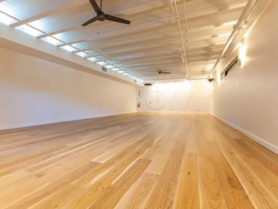 PtrBlt Miami Yoga Garage renovation photo of empty room in perspective with wood floors and ceiling fans