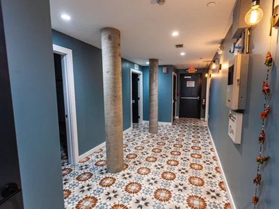PtrBlt Miami Yoga Garage renovation photo of hallway with statement floor tiles and blue walls