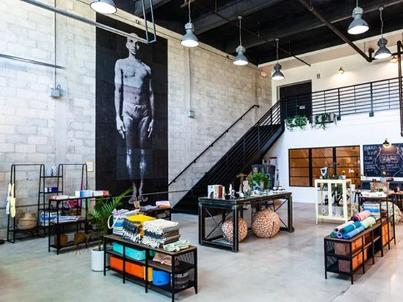 PtrBlt Miami Yoga Garage renovation photo of the lobby with white brick walls and a black-and-white-mural of a standing yogi